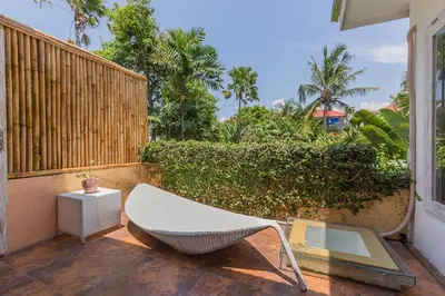 a white chair sitting on a patio next to a fence at Villa Odil, Great Value 700m beach & 15m pool in Seminyak