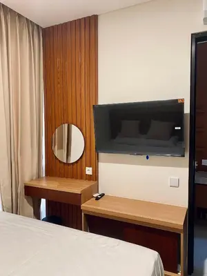 a hotel room with a bed and a flat screen tv at Villa Bun Blessi in Pesanggaran