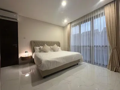 a bedroom with a bed and a large window at Villa Bun Blessi in Pesanggaran