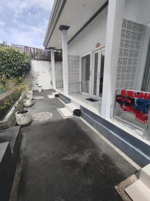 a patio of a house with a red couch at Kubusawah Guest House in Seminyak