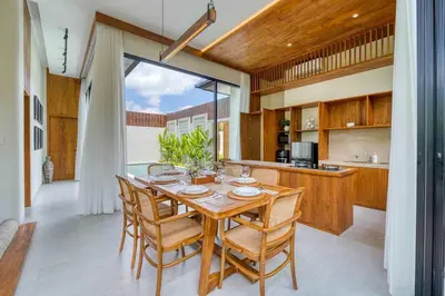 a kitchen and dining room with a wooden table and chairs at Tropical 3BR Villa 2 Private Pools in Jimbaran in Jimbaran