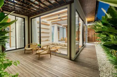 a balcony with a couch and a table and chairs at Tropical 3BR Villa 2 Private Pools in Jimbaran in Jimbaran