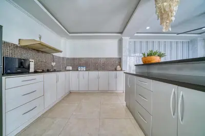 a large kitchen with white cabinets and a ceiling at Rumah Bella Private Villa 3 Bedroom 3 Bathroom in Jimbaran