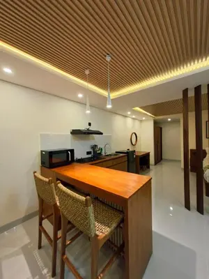 a kitchen with a wooden table and two chairs at Seminyak Apartment 37 in Seminyak