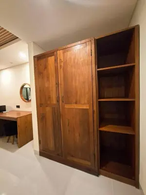 a wooden cabinet in a room with a desk at Seminyak Apartment 37 in Seminyak
