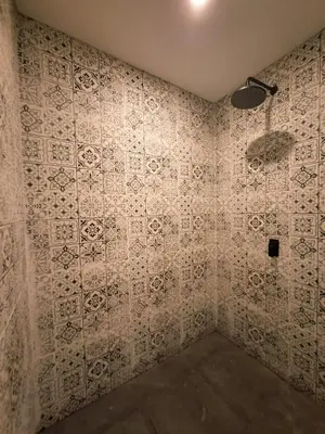 a bathroom with a tiled wall with a shower at Seminyak Apartment 37 in Seminyak