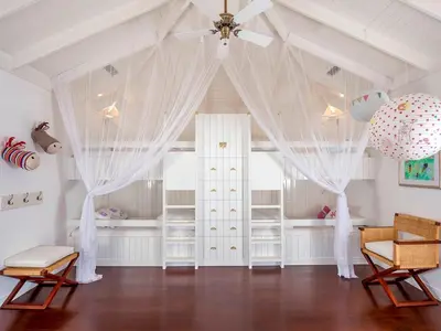 a room with a crib with curtains and a ceiling at Villa Lulito in Seminyak