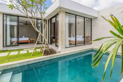 a villa with a swimming pool and a bedroom at Jimbaran Villa in Jimbaran