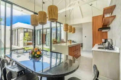 a dining room with a glass table in a kitchen at Jimbaran Villa in Jimbaran