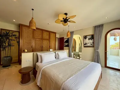 a bedroom with a large bed and a ceiling fan at Luxury Berawa Private 3BR Villa With Butler in Canggu