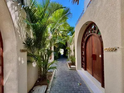 an alley with a wooden door and a palm tree at Luxury Berawa Private 3BR Villa With Butler in Canggu