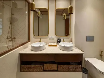 two sinks in a bathroom with two mirrors at Luxury Berawa Private 3BR Villa With Butler in Canggu