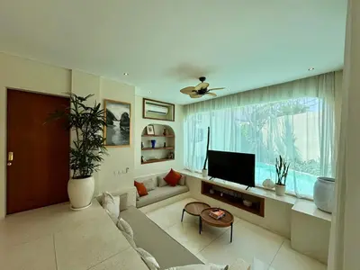a living room with a couch and a tv at Luxury Berawa Private 3BR Villa With Butler in Canggu