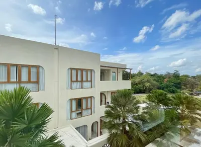 a white building with palm trees in front of it at Luxury Berawa Private 3BR Villa With Butler in Canggu