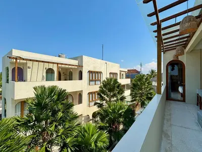 a building with palm trees in front of it at Luxury Berawa Private 3BR Villa With Butler in Canggu