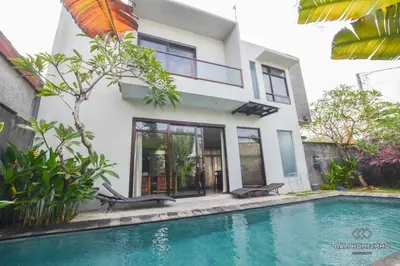 a house with a swimming pool in front of a house at Villa Ayu in Kerobokan