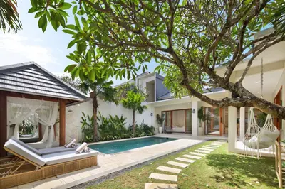 a villa with a swimming pool and a house at Alegria De La Casa Seminyak in Seminyak