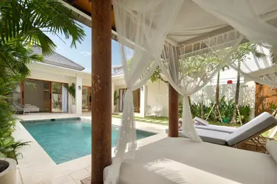 a bedroom in a villa with a swimming pool at Alegria De La Casa Seminyak in Seminyak