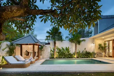 a swimming pool with a gazebo and a house at Alegria De La Casa Seminyak in Seminyak