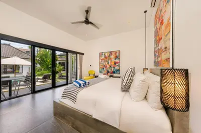 a bedroom with a large white bed with pillows at Elegant Modern 4BR Retreat in the Heart of Berawa in Canggu