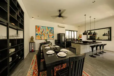a dining room with a table and a kitchen at Elegant Modern 4BR Retreat in the Heart of Berawa in Canggu