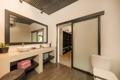 a bathroom with two sinks and a mirror at Elegant Modern 4BR Retreat in the Heart of Berawa in Canggu