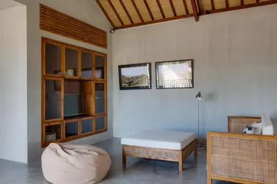 a living room with a couch and a table and a chair at ZIN Berawa Villas & Bungalows in Canggu