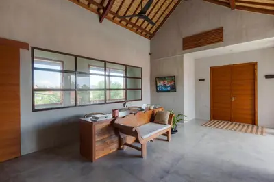 a living room with a desk and a wooden door at ZIN Berawa Villas & Bungalows in Canggu