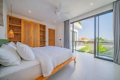 a bedroom with a large bed and a large window at Luxury 4BR Villa Private Pool & Sea Horizon in Kerobokan