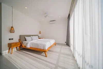 a bedroom with a bed and a large window at Luxury 4BR Villa Private Pool & Sea Horizon in Kerobokan