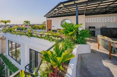 a balcony of a building with plants on it at Luxury 4BR Villa Private Pool & Sea Horizon in Kerobokan