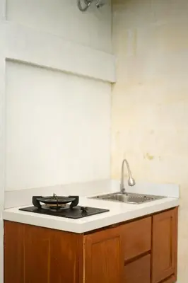 a kitchen with a stove and a sink at De Awan Villa in Kerobokan