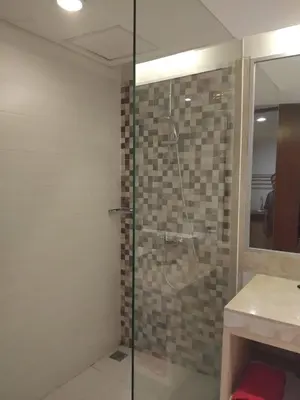 a bathroom with a shower with a glass door at Sweet Condo in Seminyak