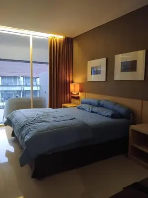 a bedroom with a large bed and a window at Sweet Condo in Seminyak