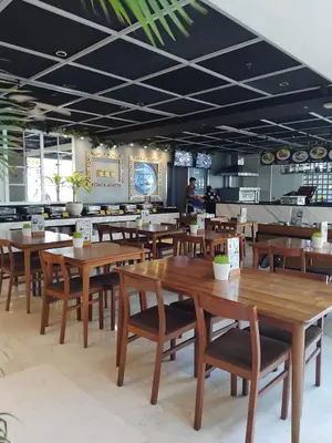 a dining room with wooden tables and chairs at Sweet Condo in Seminyak