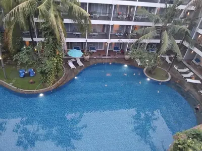 a large pool in the middle of a building at Sweet Condo in Seminyak