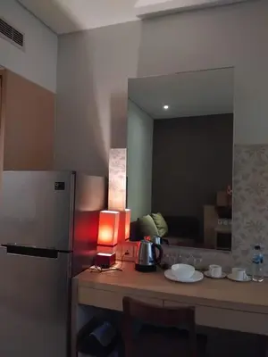 a kitchen with a counter with a refrigerator and a mirror at Sweet Condo in Seminyak