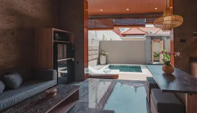 a living room with a couch and a swimming pool at Dikubu Belong in Seminyak