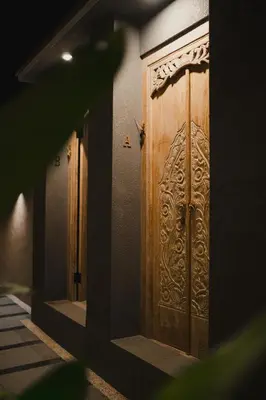 a pair of wooden doors on a building at Dikubu Belong in Seminyak