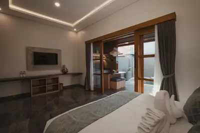 a bedroom with a large bed and a television at Dikubu Belong in Seminyak