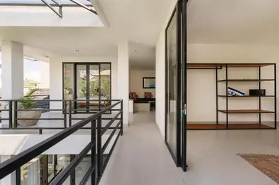 a hallway of a house with glass doors and stairs at Spacious 5BR Modern Simplicity, Near Canggu's Best in Canggu
