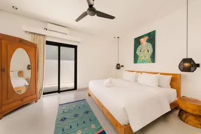 a bedroom with a bed and a mirror at Spacious 5BR Modern Simplicity, Near Canggu's Best in Canggu