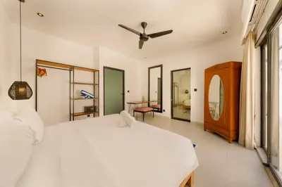 a bedroom with a white bed with a ceiling fan at Spacious 5BR Modern Simplicity, Near Canggu's Best in Canggu
