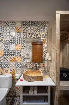 a bathroom with a sink and a toilet and tiles at Villa Gema Asri - Boho Chic Oasis in Central Petitenget in Seminyak