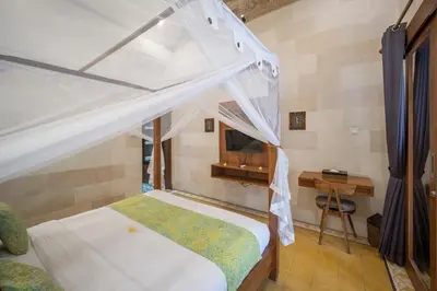 a bedroom with a bed with a canopy and a desk at Villa Gema Asri - Boho Chic Oasis in Central Petitenget in Seminyak
