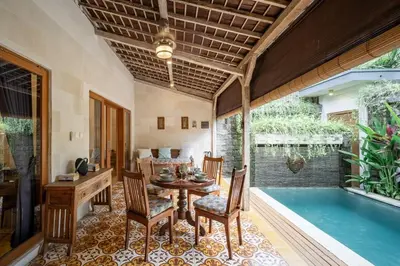 a dining room with a table and a swimming pool at Villa Gema Asri - Boho Chic Oasis in Central Petitenget in Seminyak