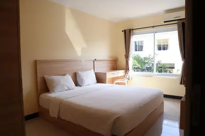 a bedroom with a large bed with a window at Sunrise Aventus Villa Nusa Dua in Nusa Dua