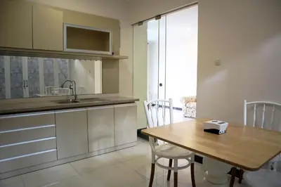 a kitchen with a wooden table and a sink at Sunrise Aventus Villa Nusa Dua in Nusa Dua