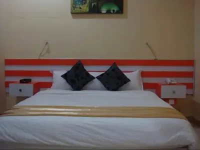 a bedroom with a bed with a red and white headboard at Mutiara Mansion Aparthotel in Seminyak