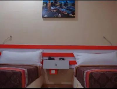 a room with two beds and a picture on the wall at Mutiara Mansion Aparthotel in Seminyak